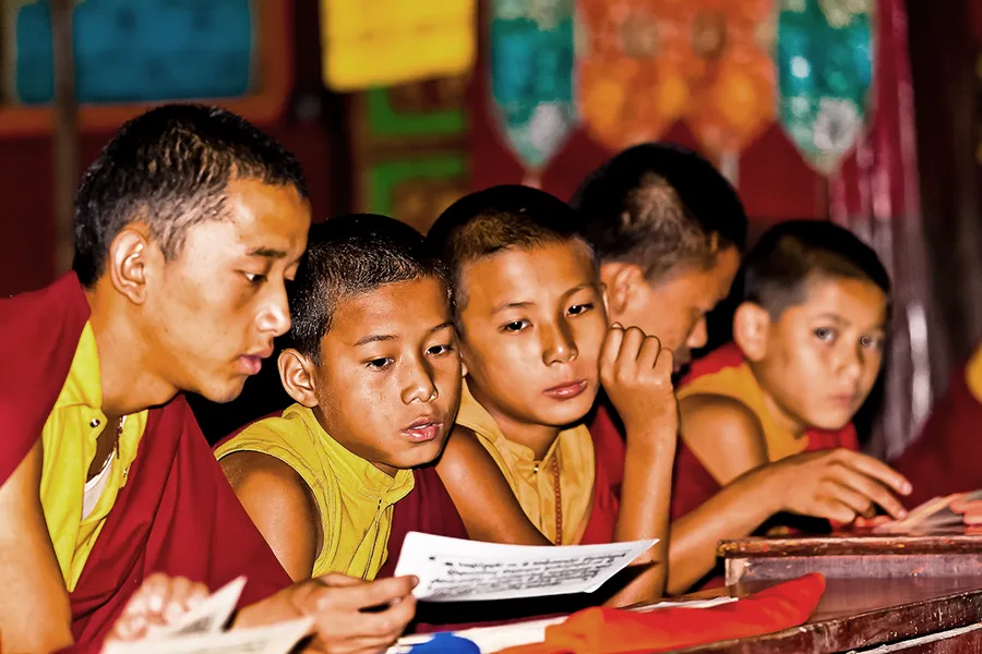 Eine Gruppe von buddhistischen Mönchen liest in Büchern und Schriften.